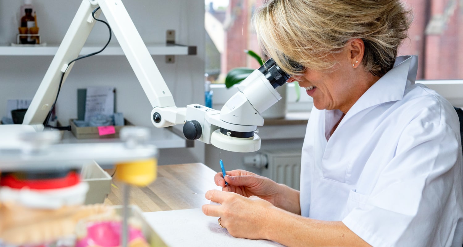 Zahnärztin arbeitet mit einem Dentalmikroskop